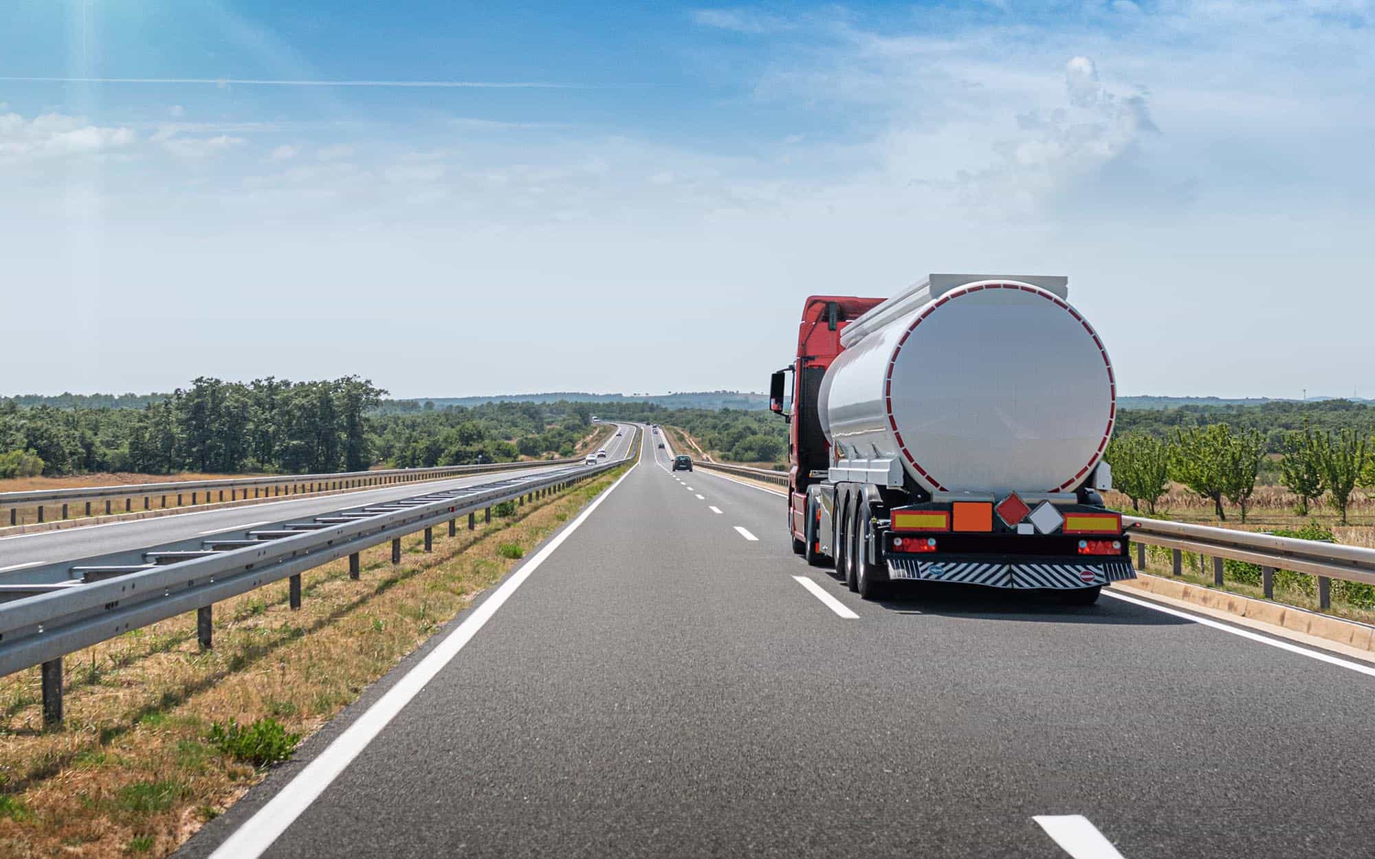 Back view of a semi truck driving down the road