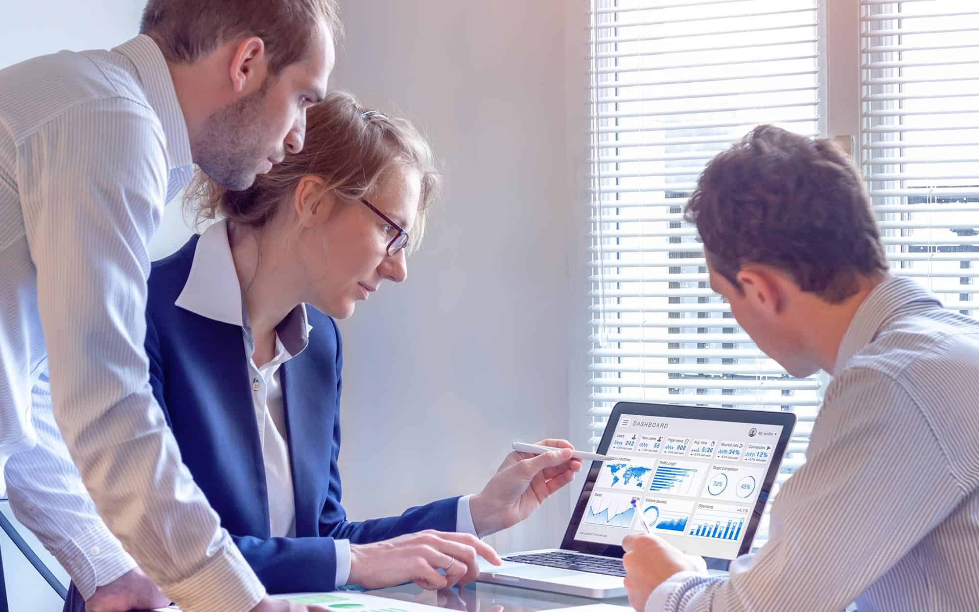 Group of people looking at analytics on computer