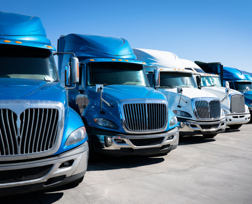 Fleet of blue 18 wheeler semi trucks